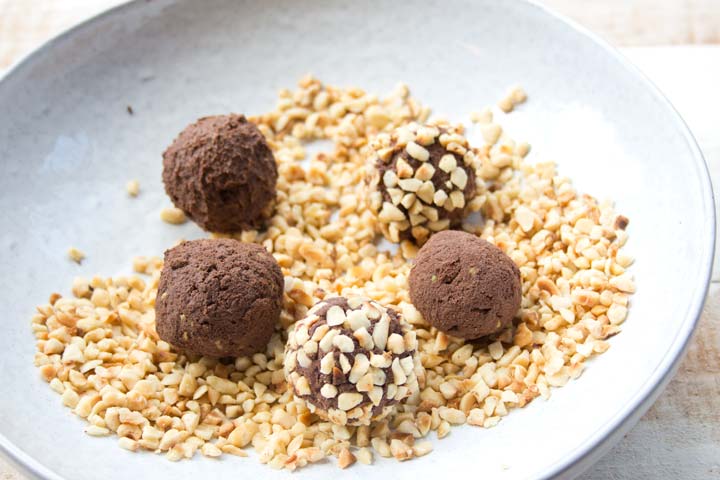 rolling chocolate truffles in chopped hazelnuts