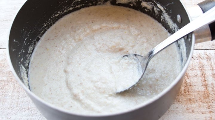 coconut flour porridge in a saucepan and a spoon