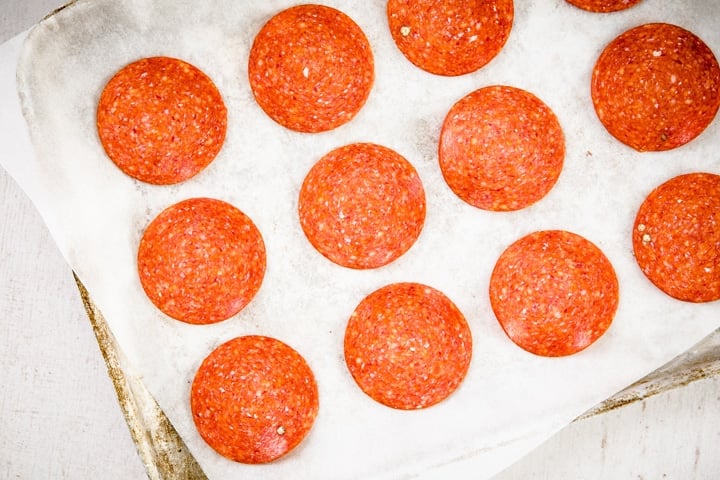 pepperoni slices on a baking tray lined with parchment paper