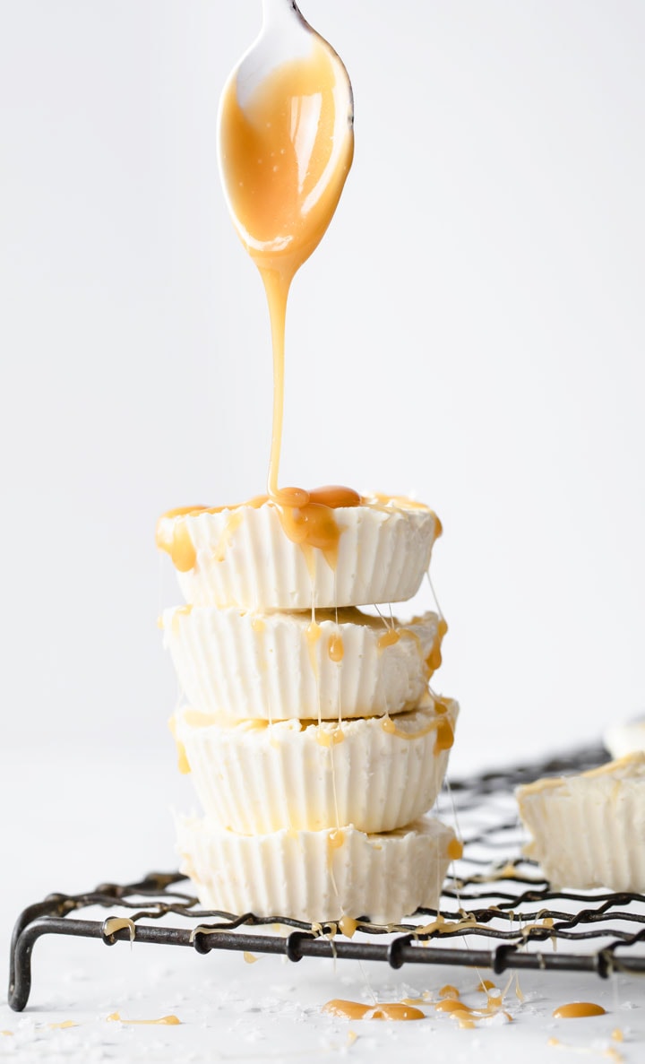 a stack of keto fat bombs with a spoon dripping caramel sauce over it