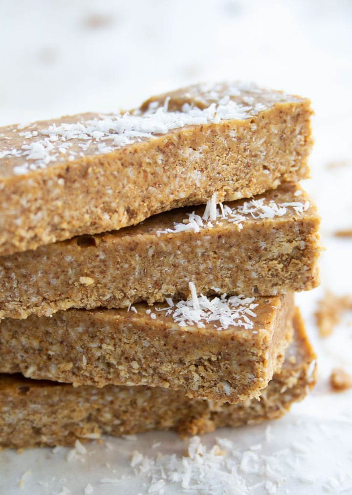 a stack of almond butter bars topped with desiccated coconut