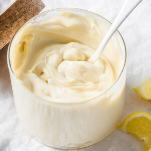a spoon sticking in a jar or thick and creamy keto mayonnaise