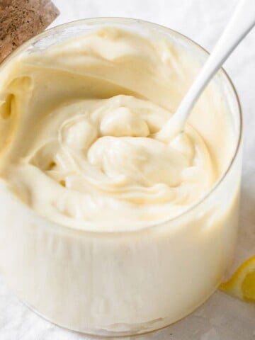 a spoon sticking in a jar or thick and creamy keto mayonnaise