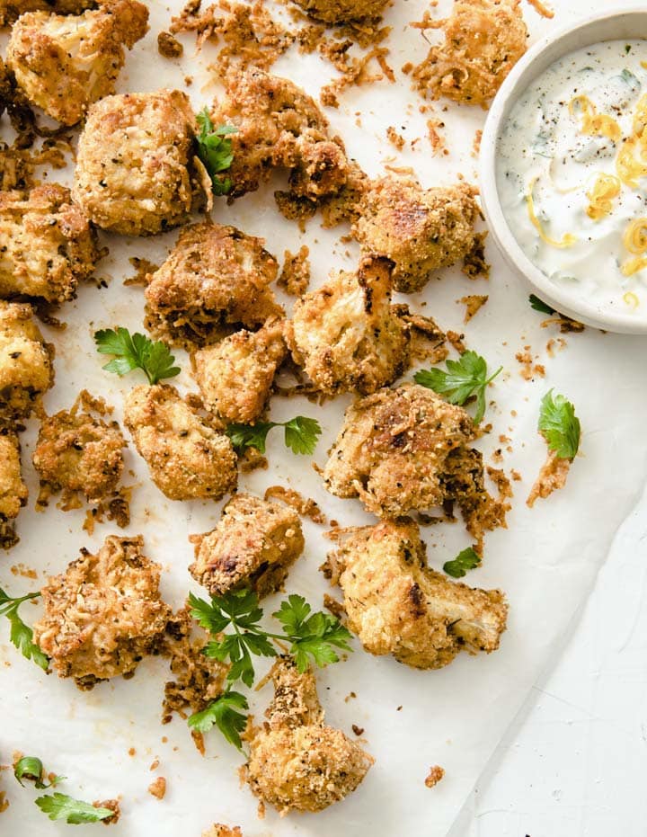 cauliflower popcorn on baking paper with a sauce