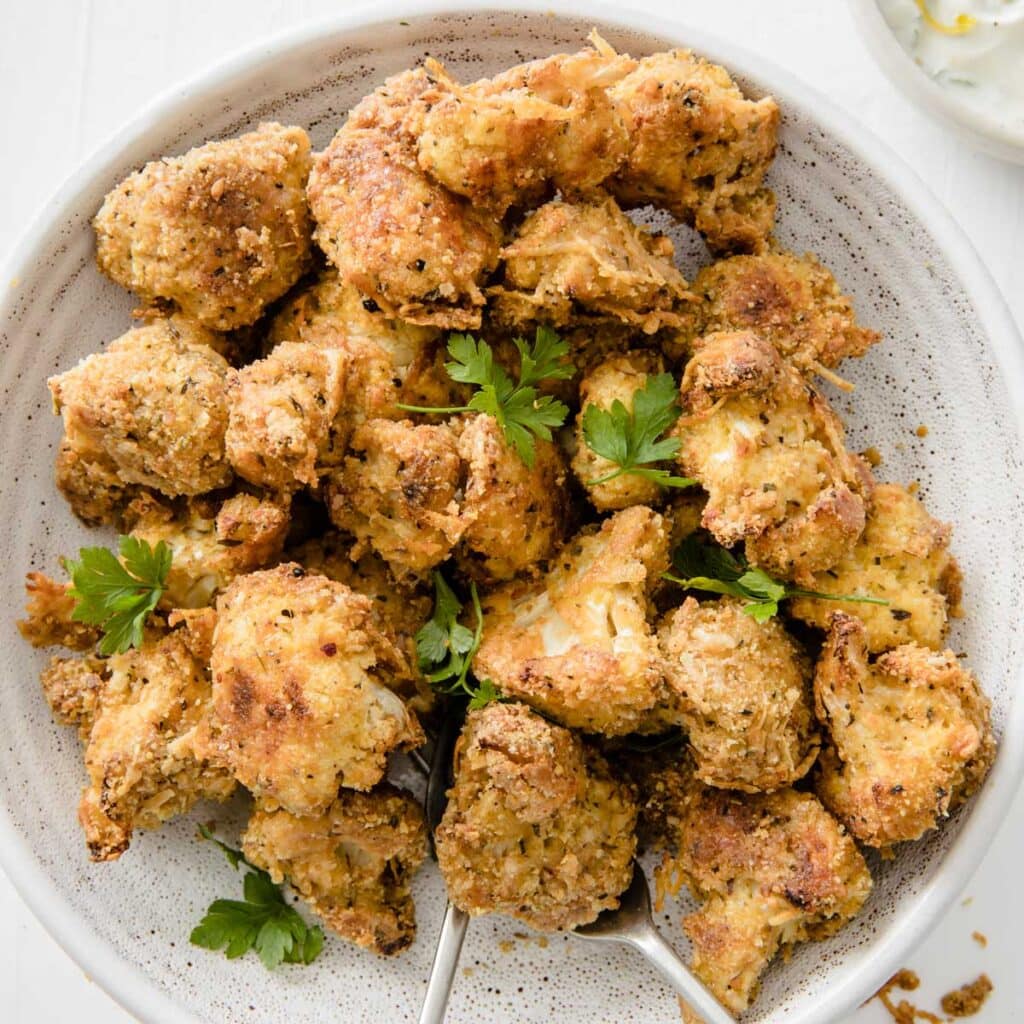 cauliflower popcorn in a bowl decorated with parsley