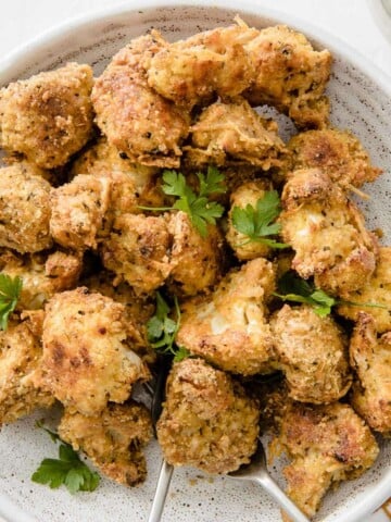 cauliflower popcorn in a bowl decorated with parsley