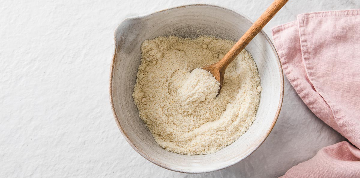 almond flour, erythritol and baking powder mixed in a bowl with a wooden spoon