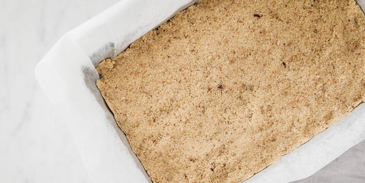 almond flour base mix pressed into a baking tin lined with parchment paper.