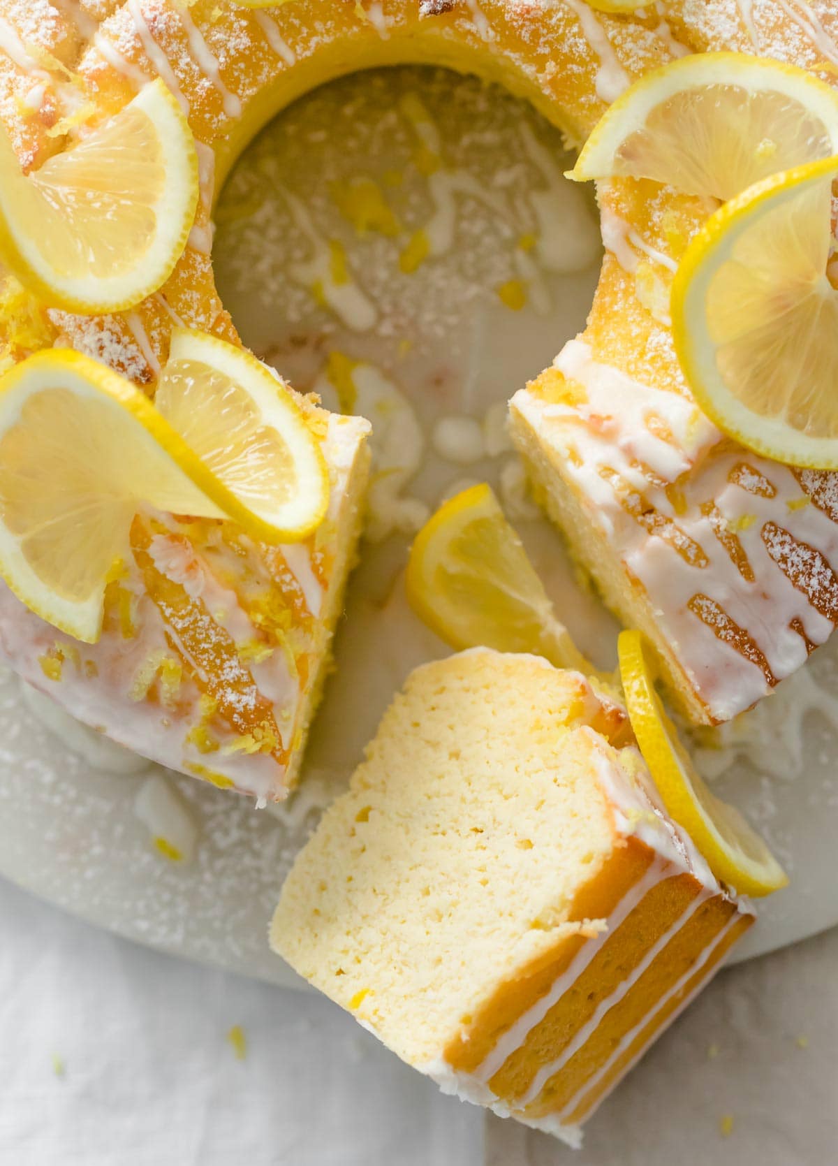 a round sugar free lemon cake with a slice cut out lying sideways