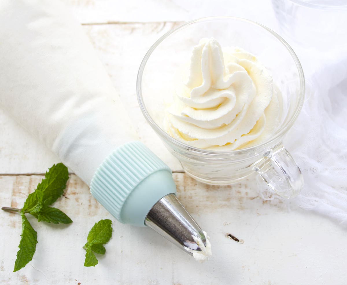 cheesecake fluff in a glass cup and a piping bag