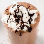 melted chocolate dripping from a chocolate milkshake topped with whipped cream