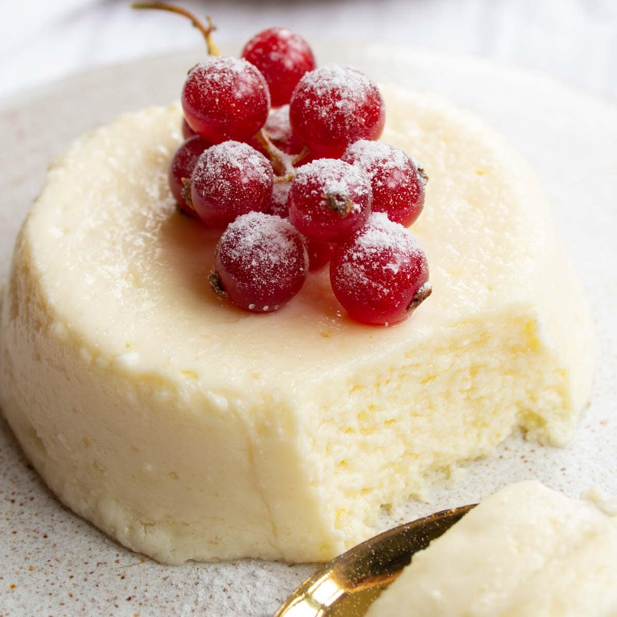 a keto microwave cheesecake on a plate with a spoonful taken out