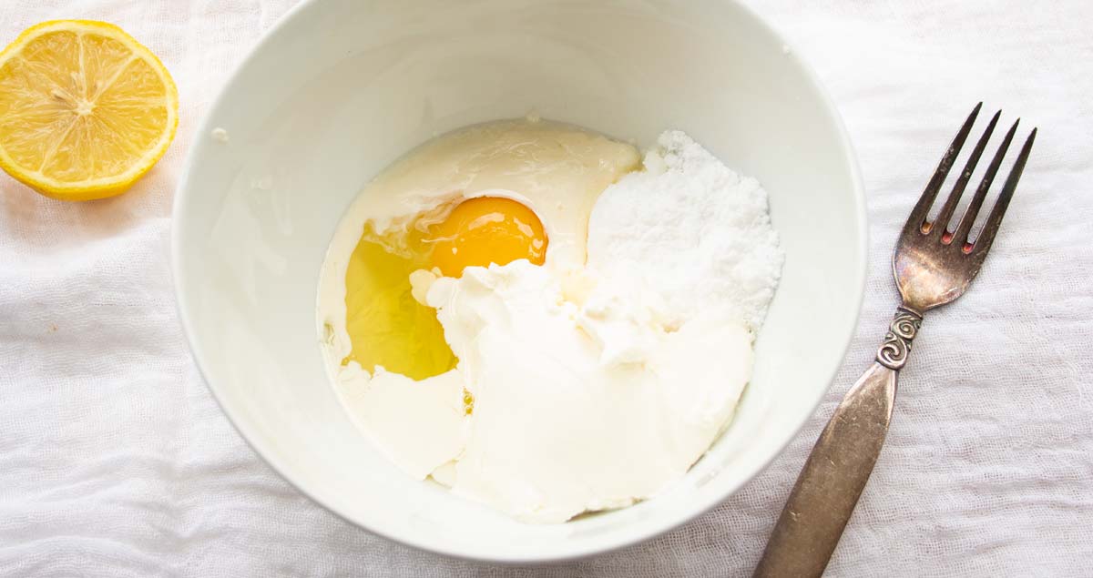 egg, cream cheese, cream, sweetener in a bowl and a fork
