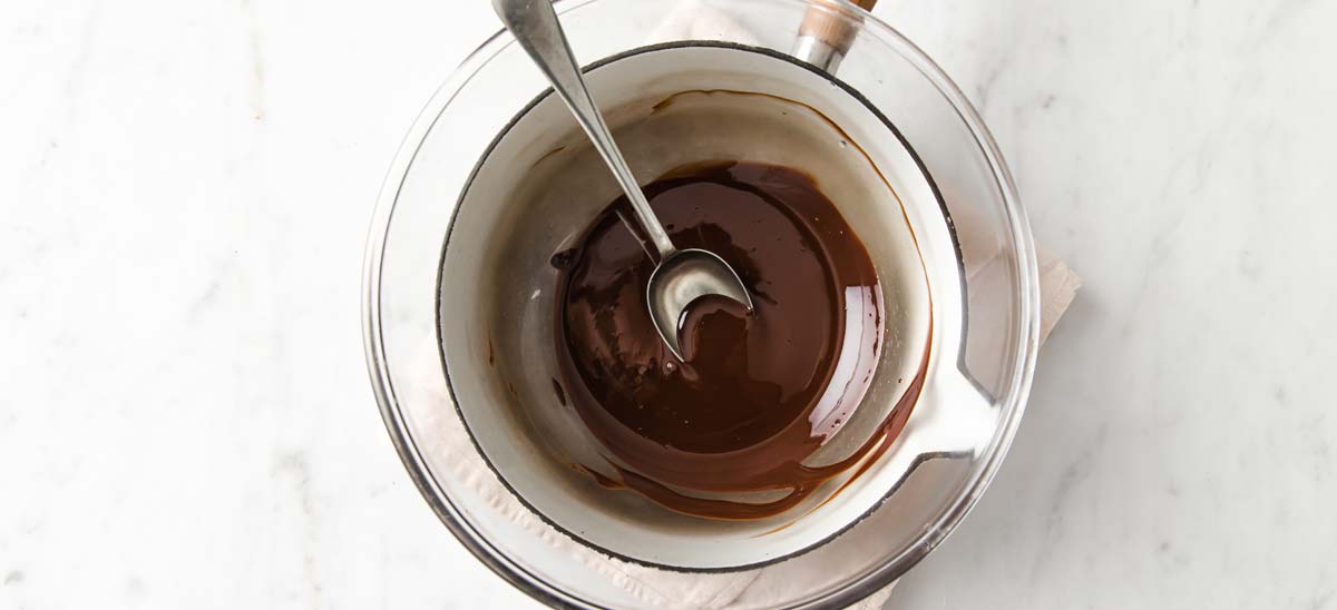 melted chocolate in a double boiler and a spoon