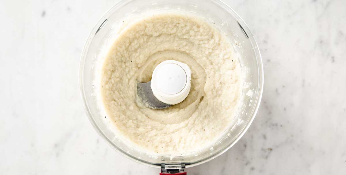 a food processor bowl with cauliflower puree