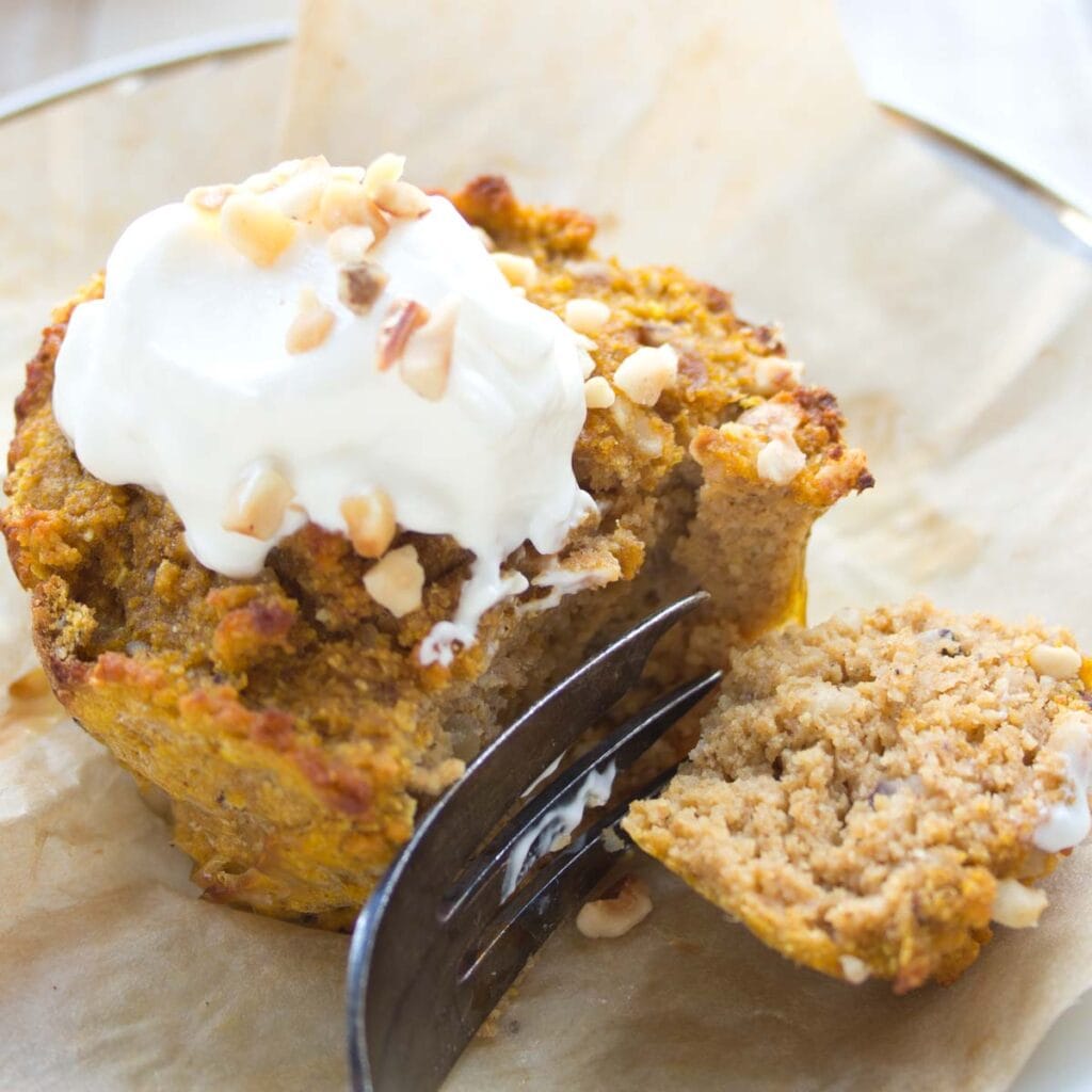 a keto pumpkin muffin with sour cream frosting