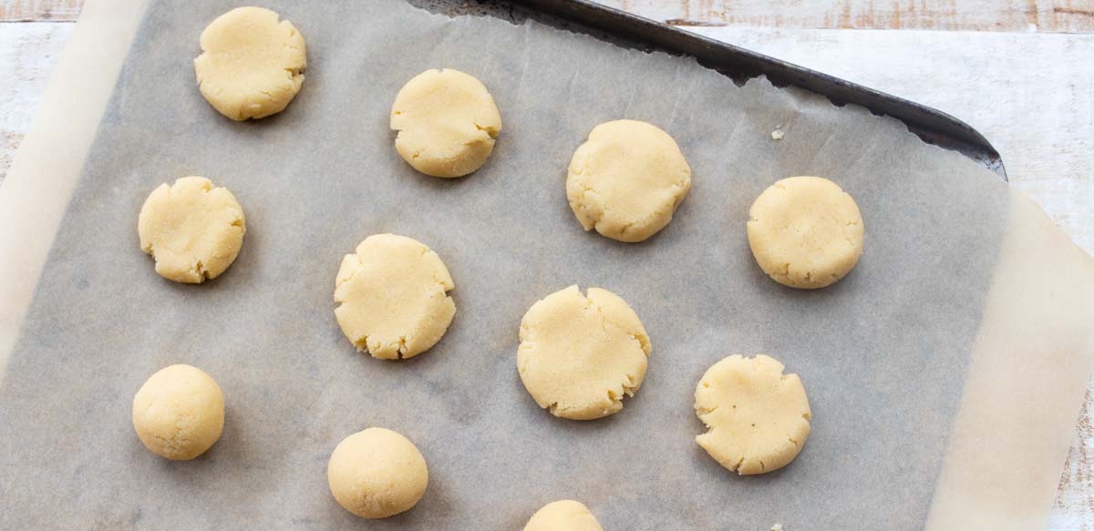unbaked cookies flattened on a baking sheet