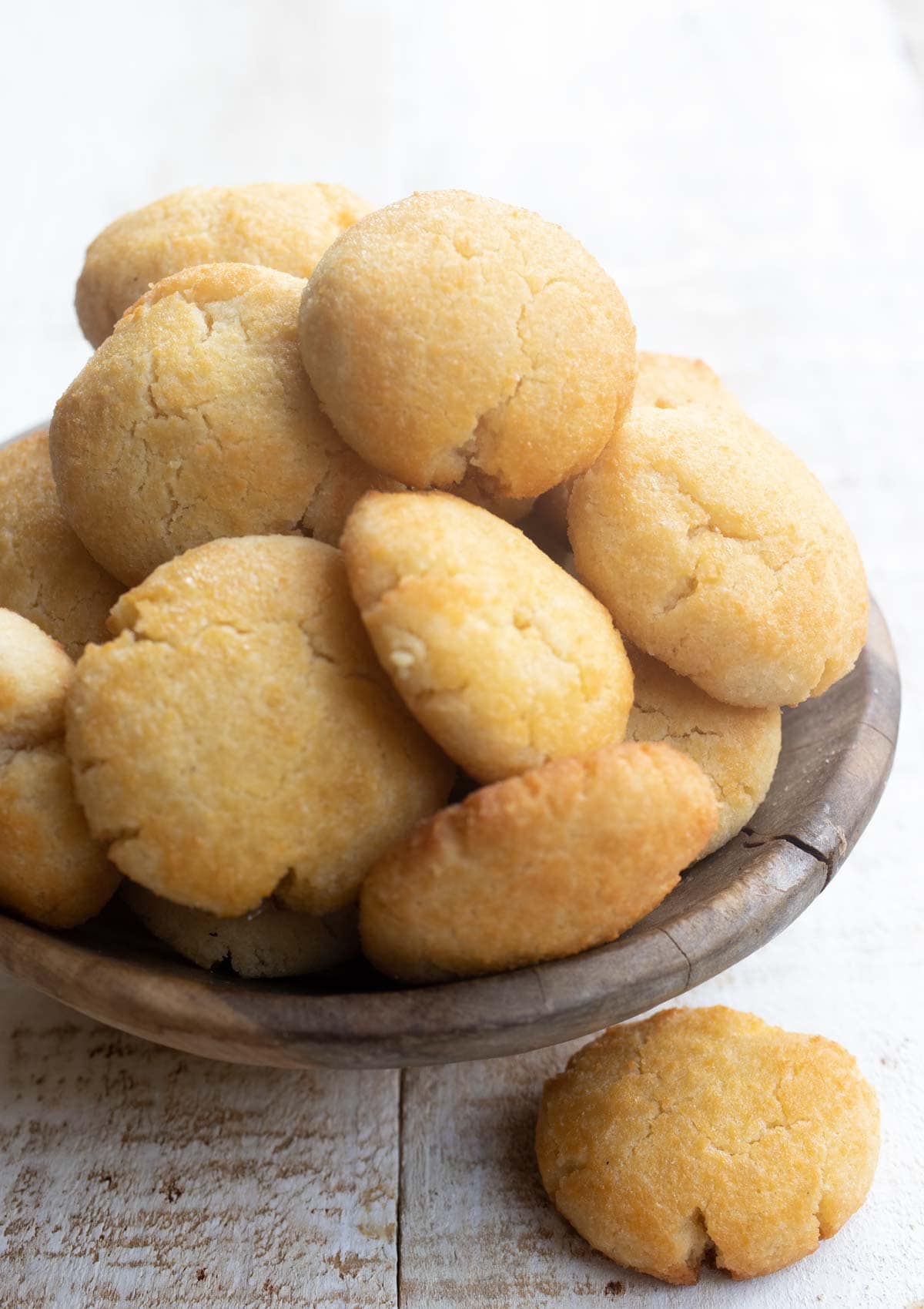 a wooden bowl stacked with cookies