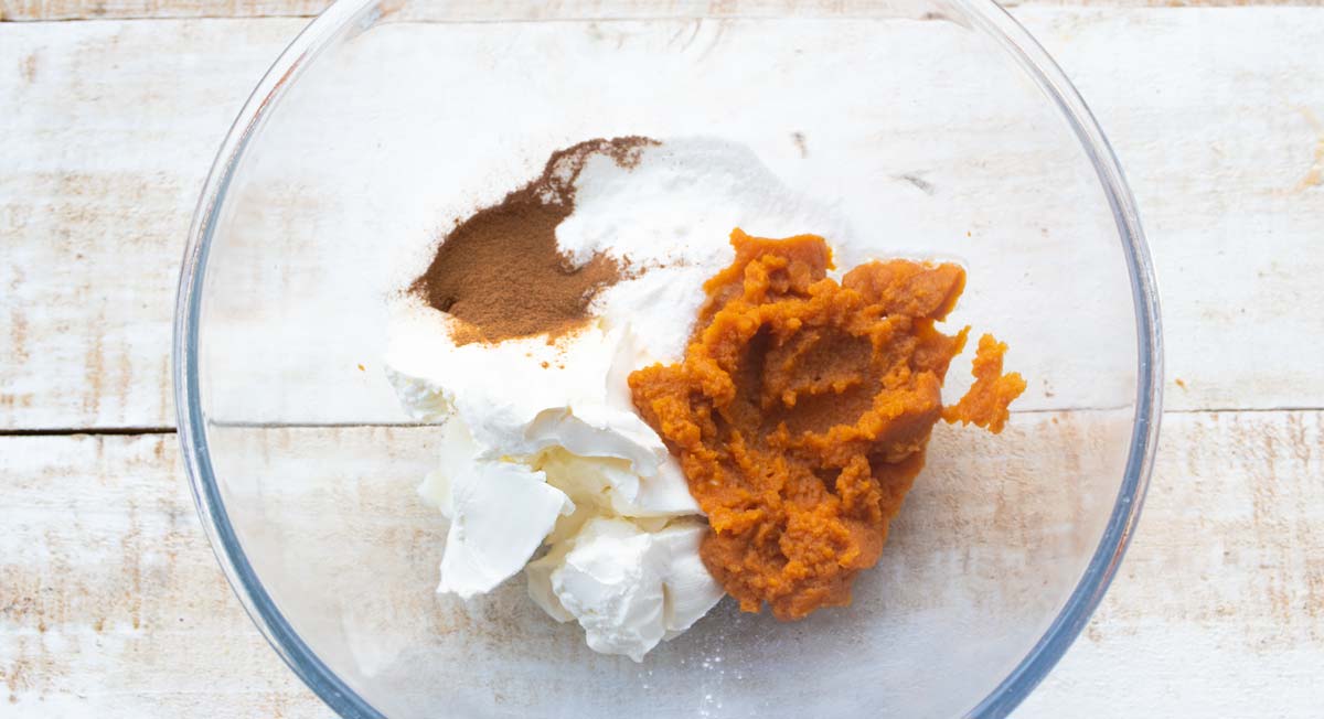 Cream cheese, pumpkin, sweetener and spices in a bowl.