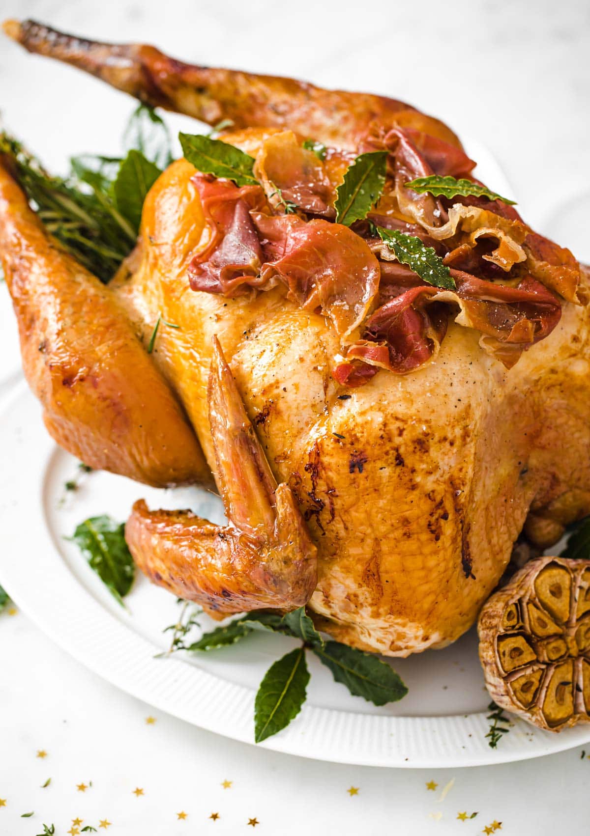 a roasted turkey stuffed with herbs and sage leaves