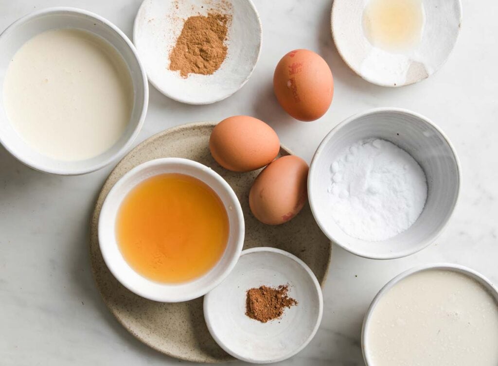 ingredients for sugar free keto eggnog in bowls and 3 eggs