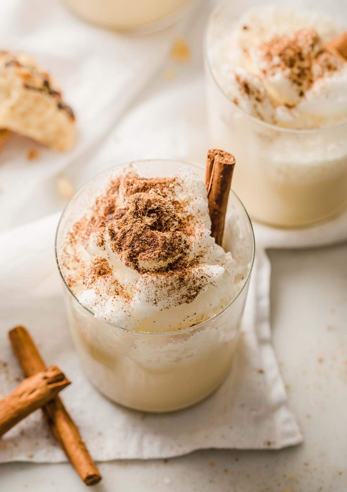 2 glasses with eggnog dusted with nutmeg and cinnamon