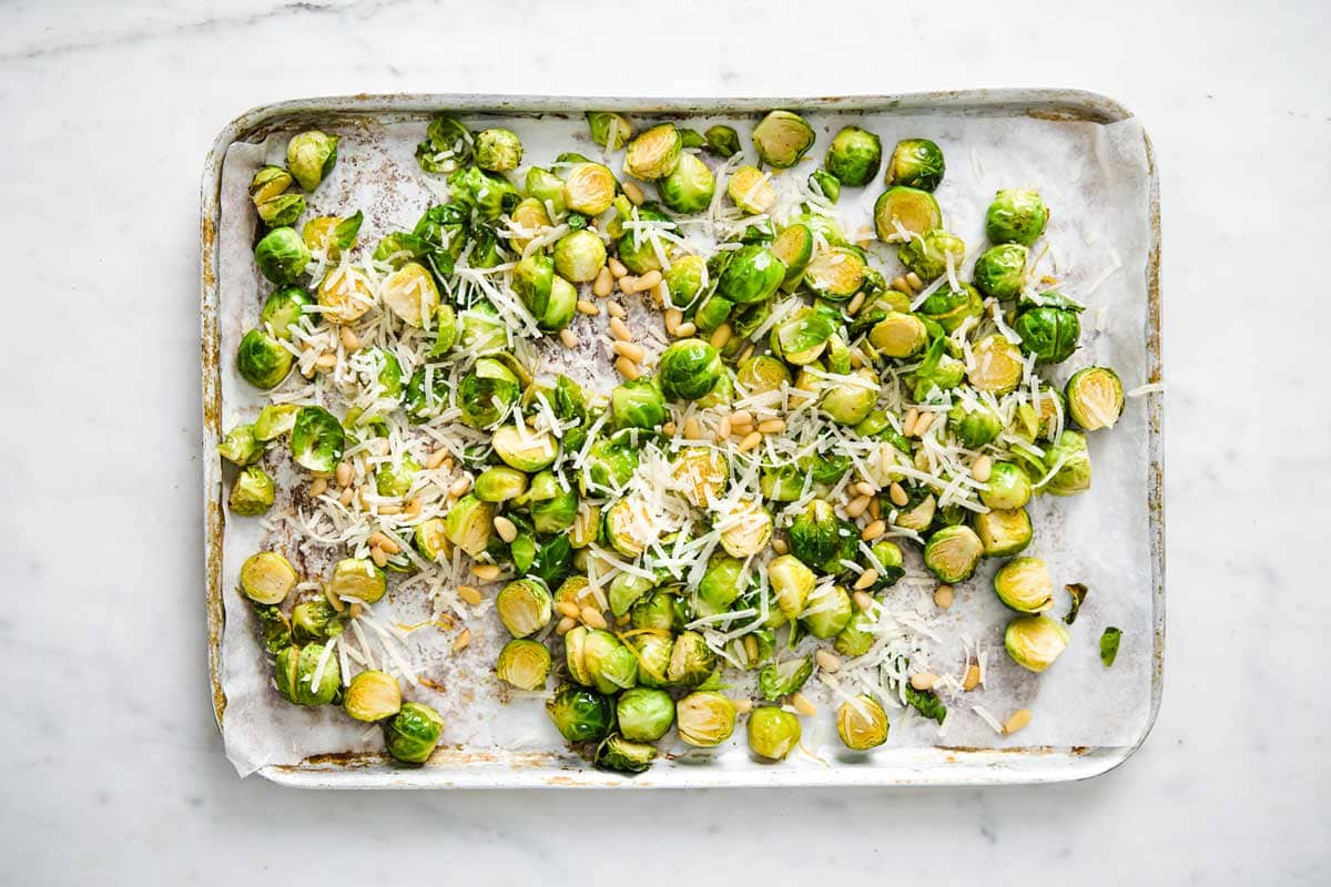 Parmesan and lemon zest over sprouts on a tray.