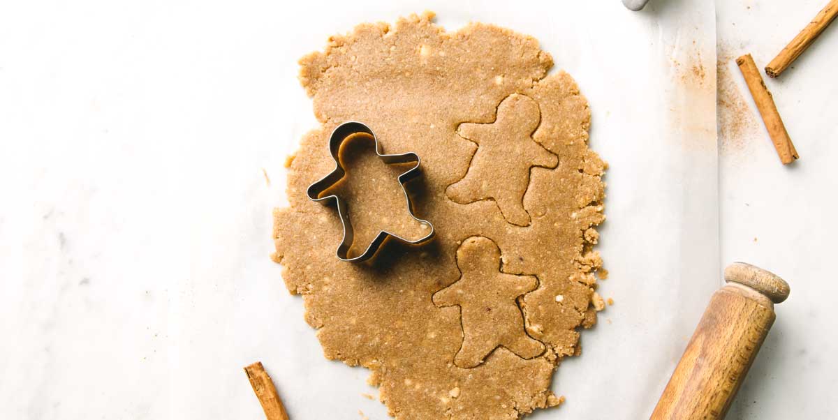 cutting out gingerbread men with a cookie cutter