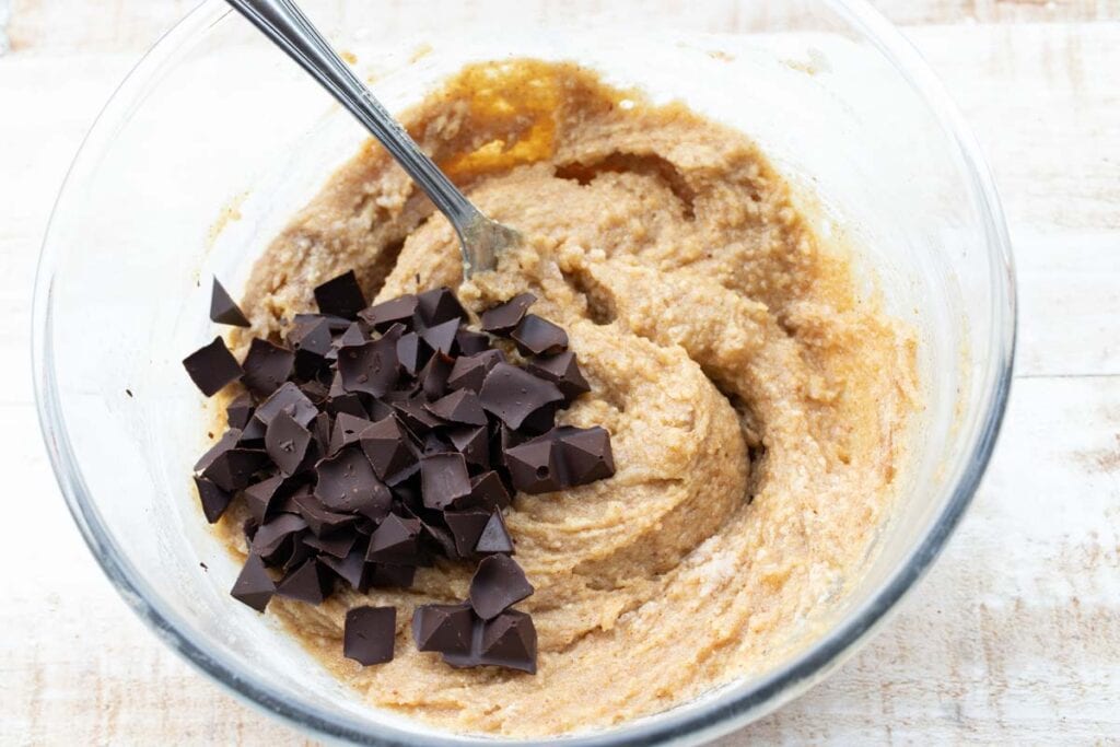 blondie batter in a bowl with chocolate chips and a fork