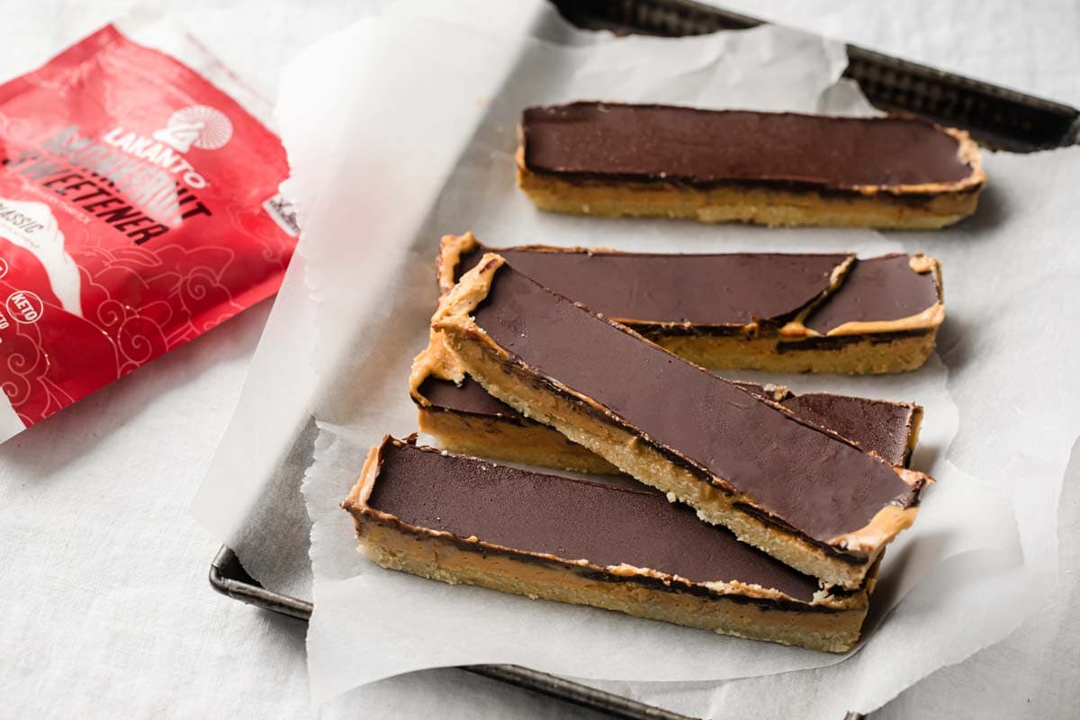 peanut butter slices with chocolate topping in a baking tray