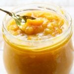 taking a spoonful of sugar free orange marmalade from a glass jar