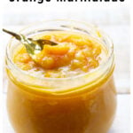taking a spoonful of orange marmalade from a jar