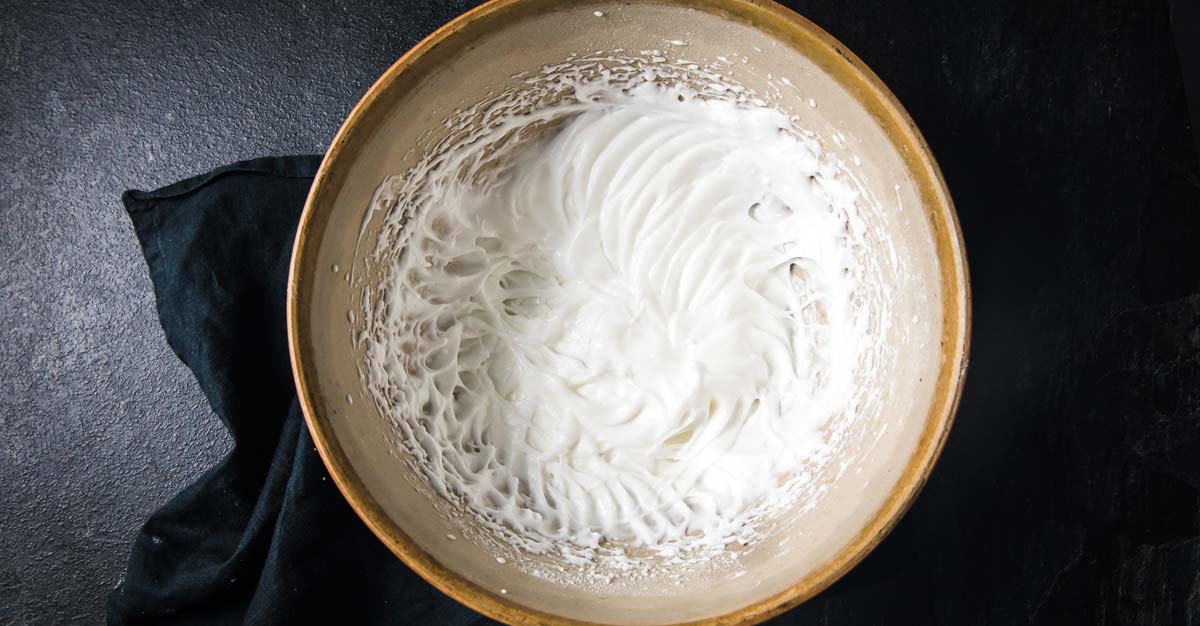 stiff egg whites in a bowl with sweetener