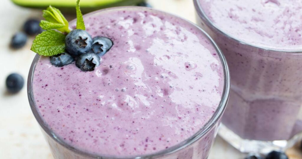 a blueberry smoothie topped with blueberries and mint