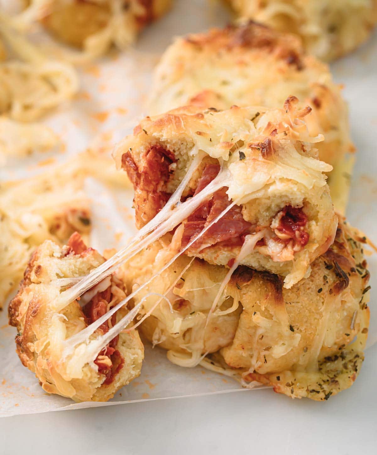 two pizza rolls stacked on top or each other showing stringy cheese