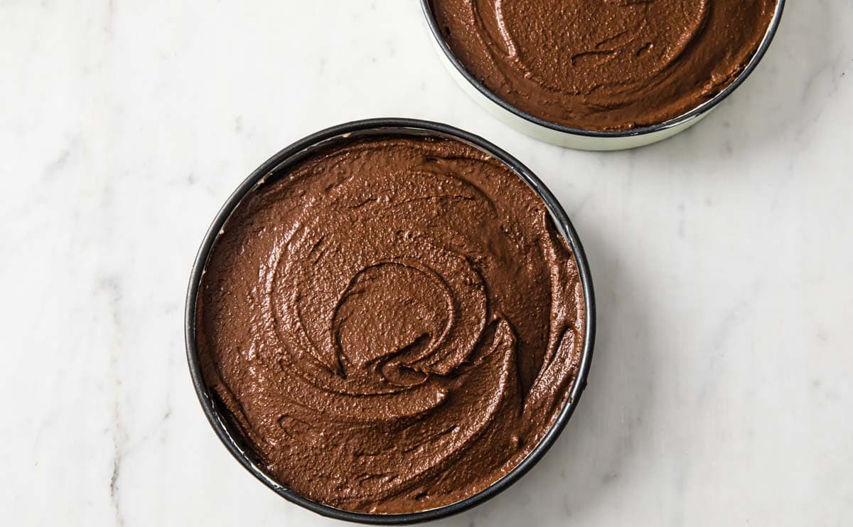 chocolate cake batter in two cake tins