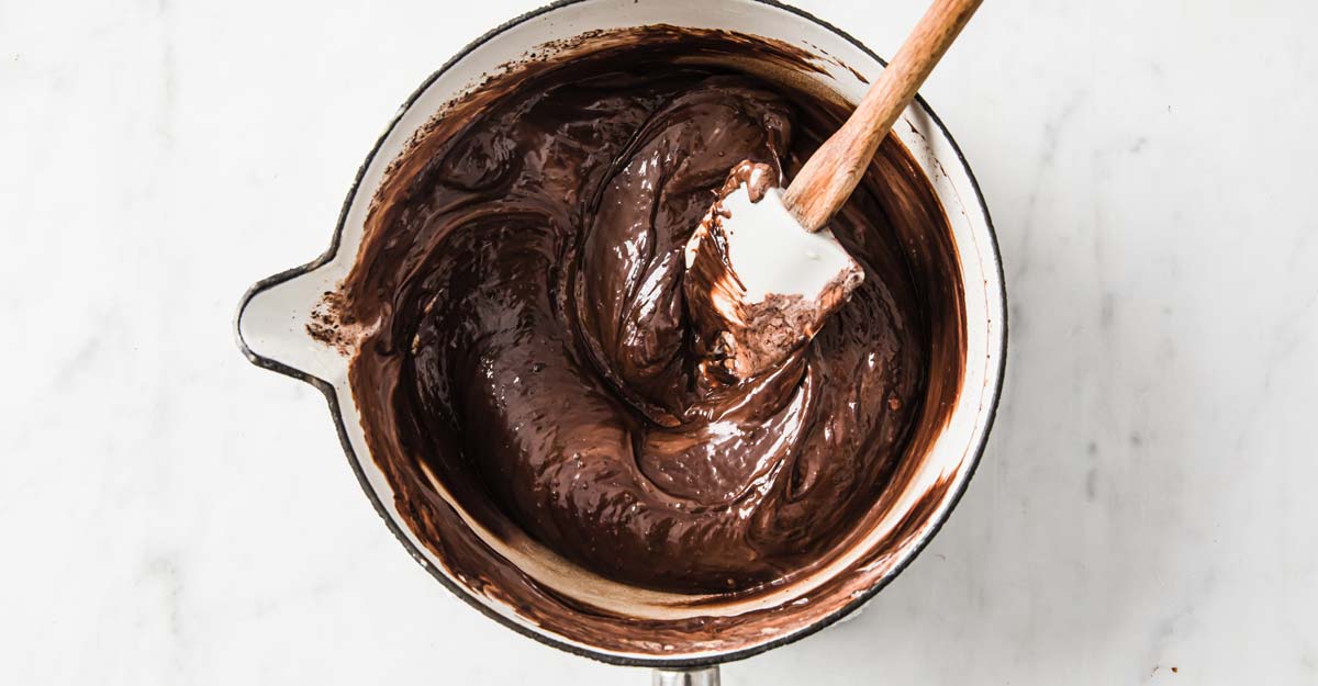 chocolate ganache in a saucepan and a spatula