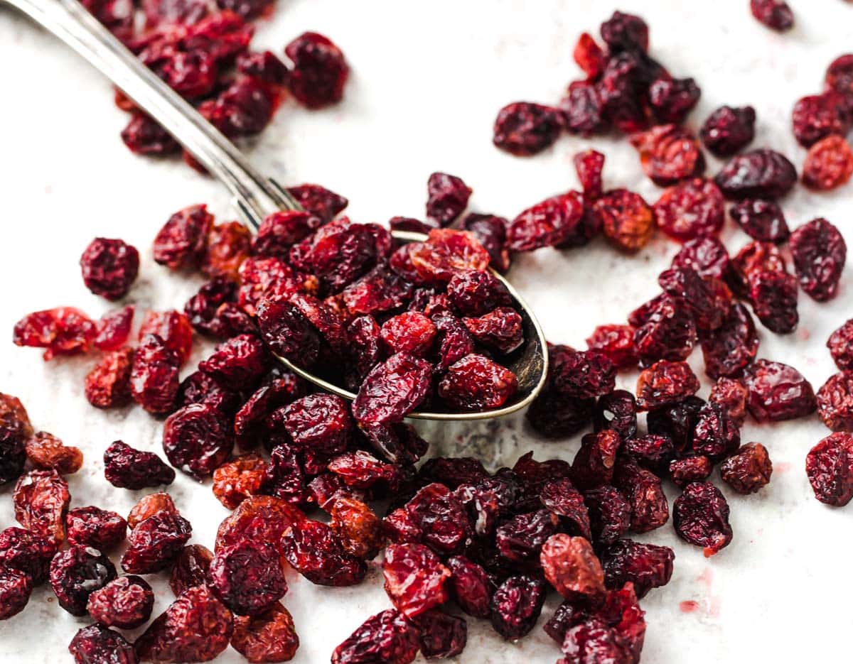 a spoon with dried cranberries on parchment paper