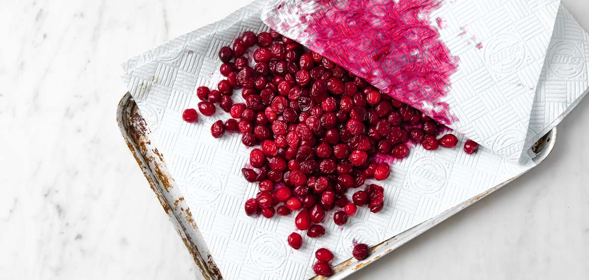 blotting juice and liquid off cranberries with a paper towel