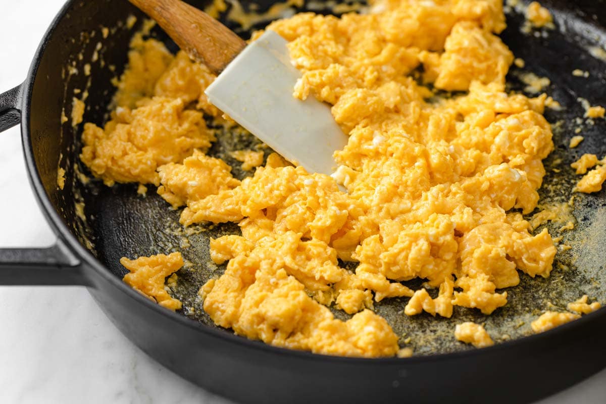 scrambling eggs in a pan with a spatula