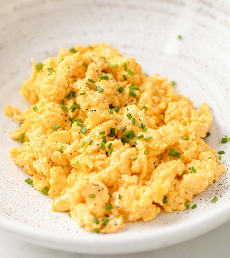scrambled eggs with chopped chives on a plate
