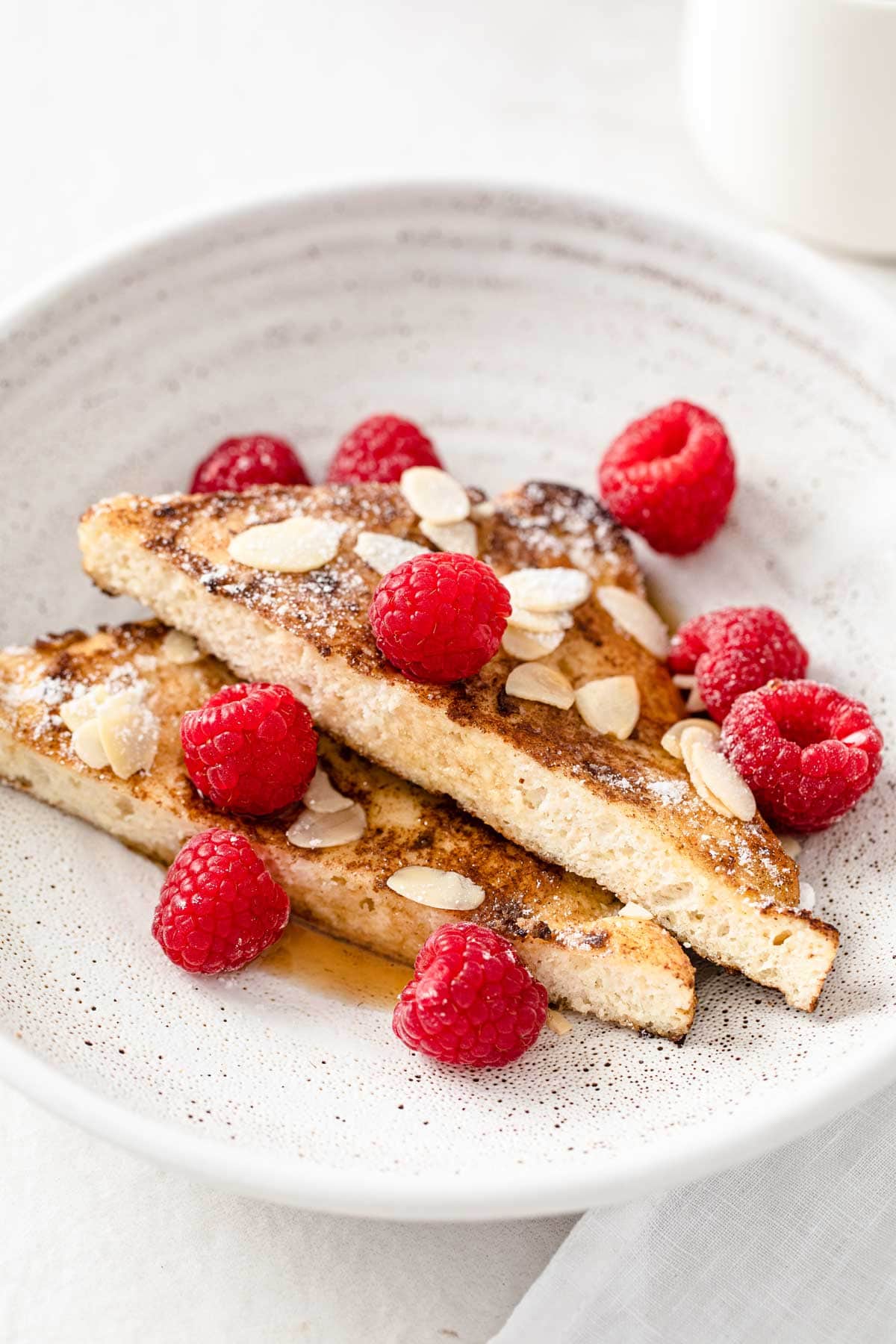 2 slices of keto french toast on a plate with raspberries