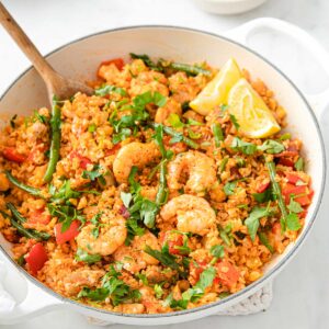 keto paella with riced cauliflower in a large pot and a wooden spoon
