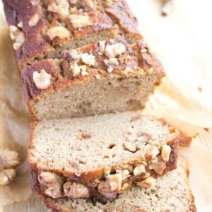 a keto banana bread topped with walnuts and sliced