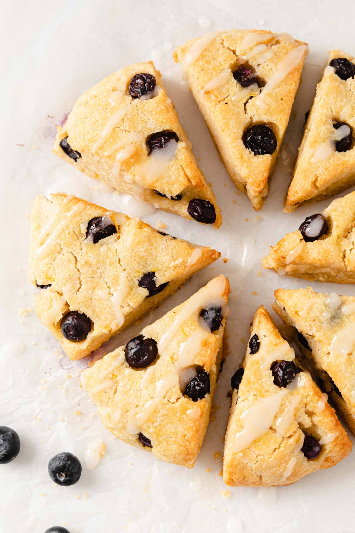 Blueberry scones arranged in a circle with lemon icing