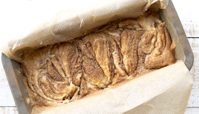 cinnamon bread batter in a loaf pan showing the swirls created with a knife