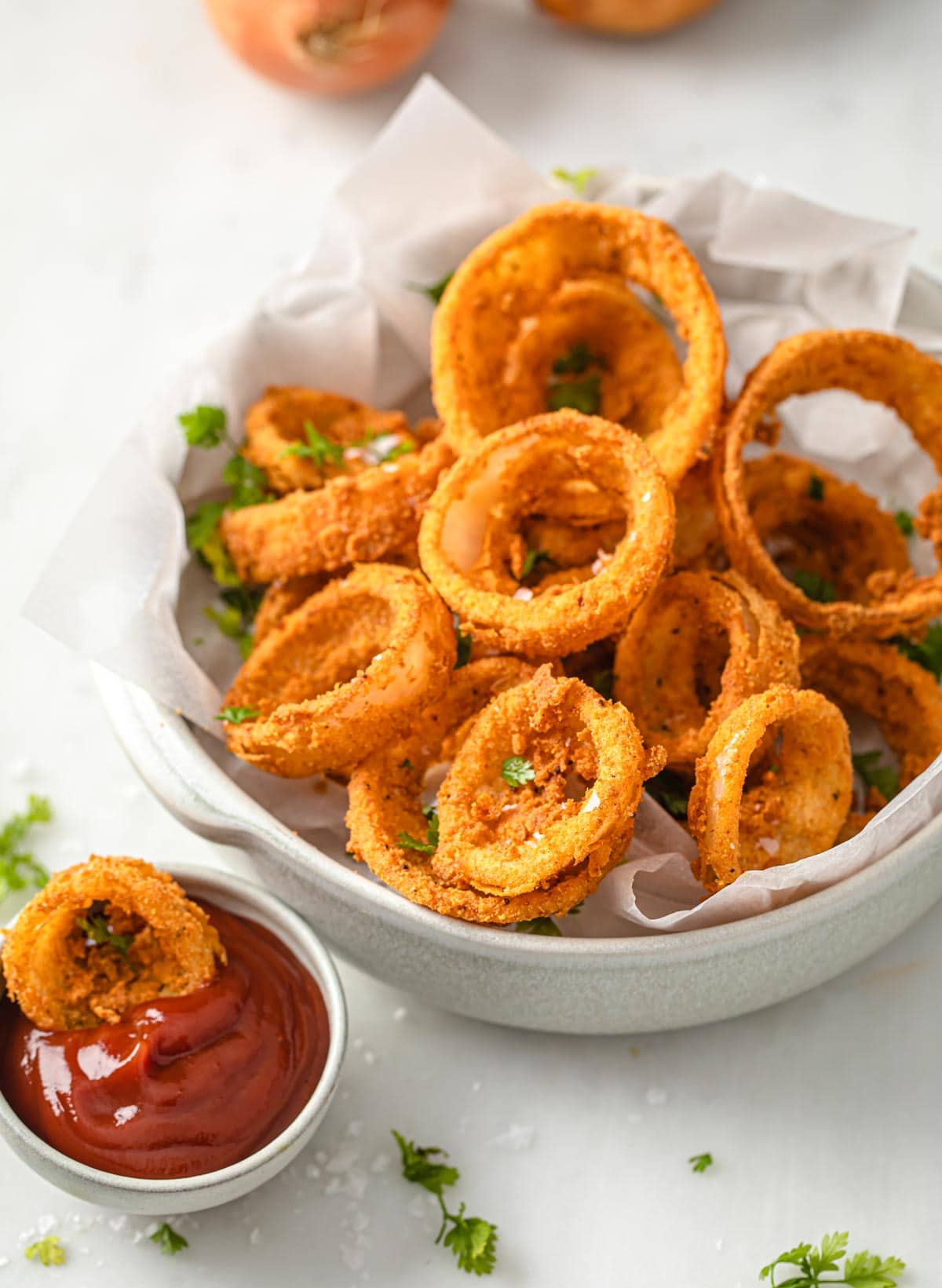 low carb onion rings in a bowl with a portion of ketchup on the side