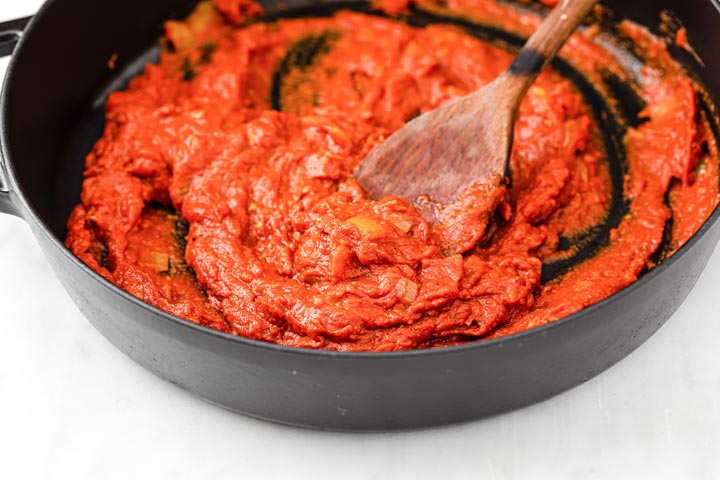 Salsa de tomate al curry en una sartén y una espátula