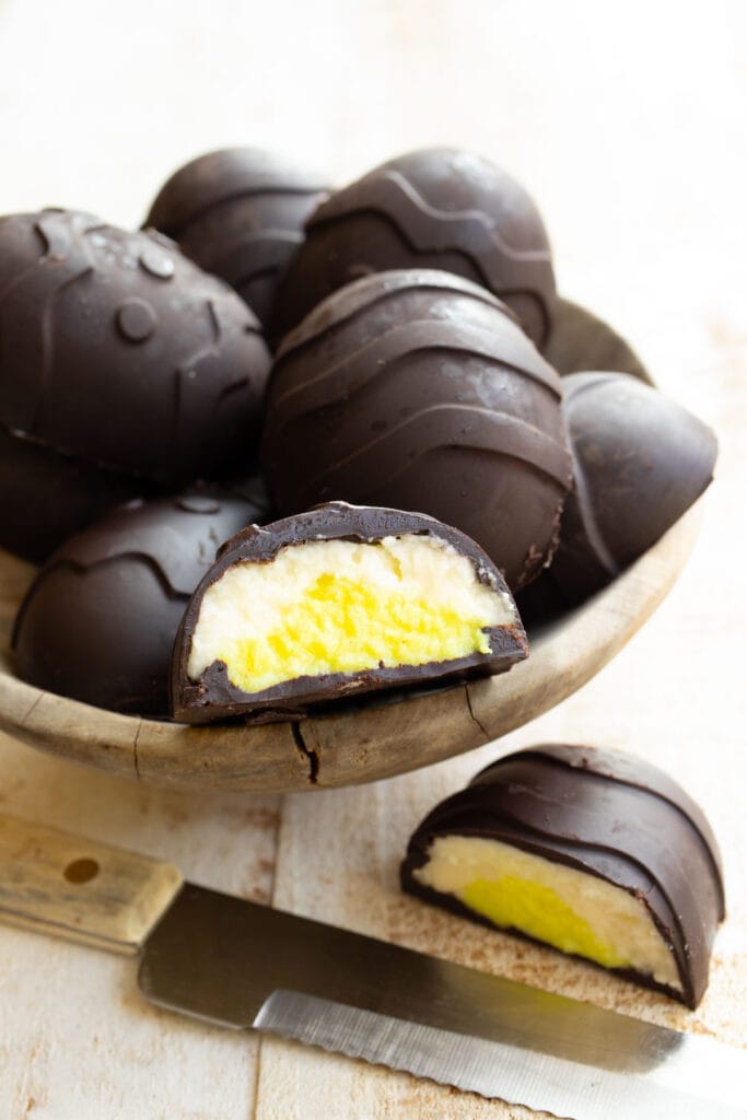 a bowl with chocolate easter eggs, one is cut open