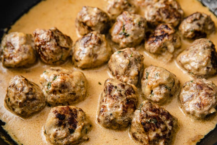 Meatballs in a cream sauce in a pan.
